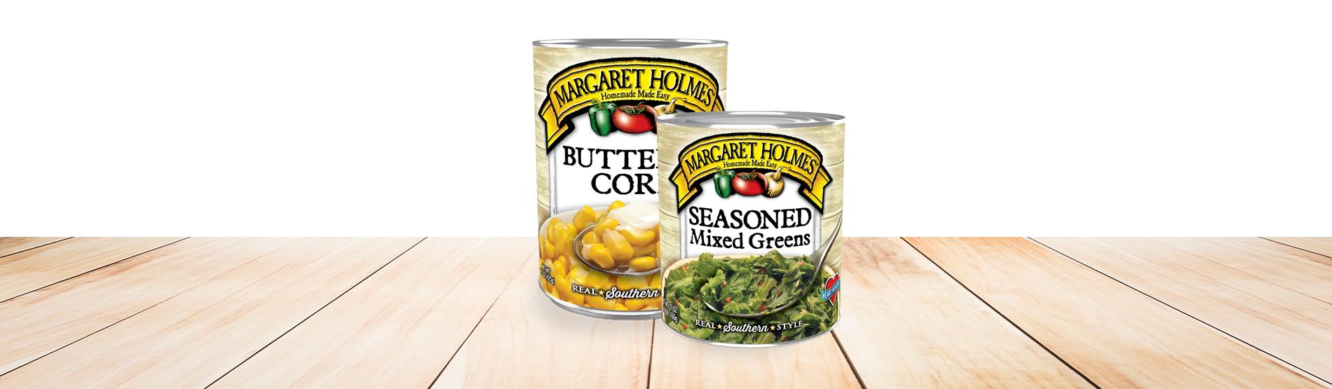 Two cans of Margaret Holmes Canned Foods on a wood table